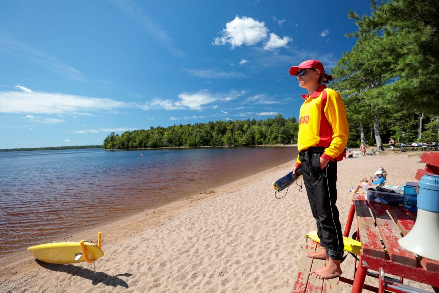 A lifeguard stands overlooking the sandy shore of Dollar Lake. 